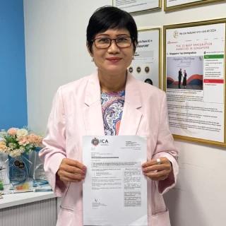 Thida, a Singapore Top Immigration client, holding their ICA approval letter