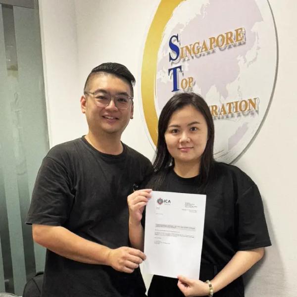 Andy, a Singapore Top Immigration client, holding their ICA approval letter
