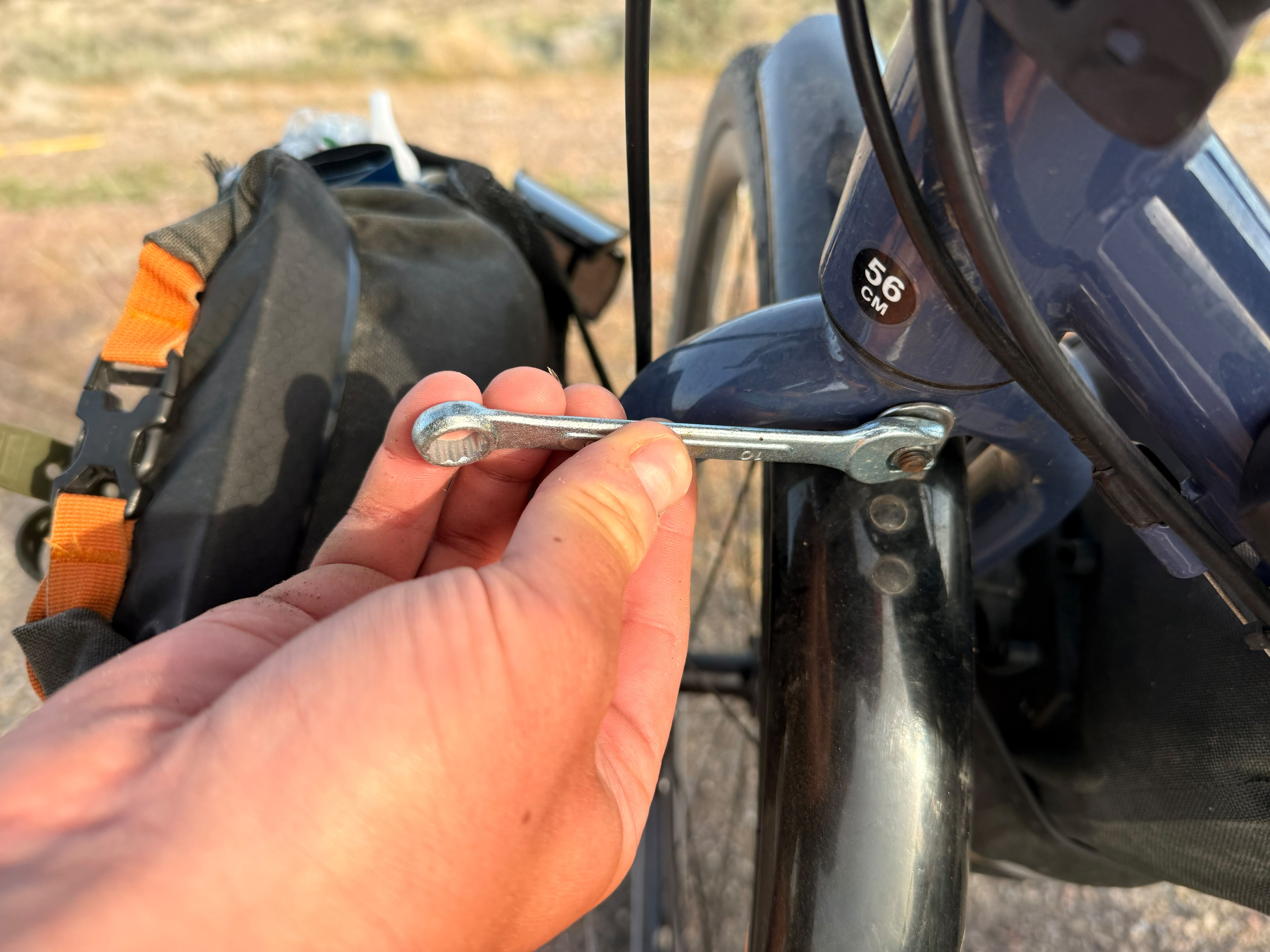 A found spanner tightening a bolt on the bicycle