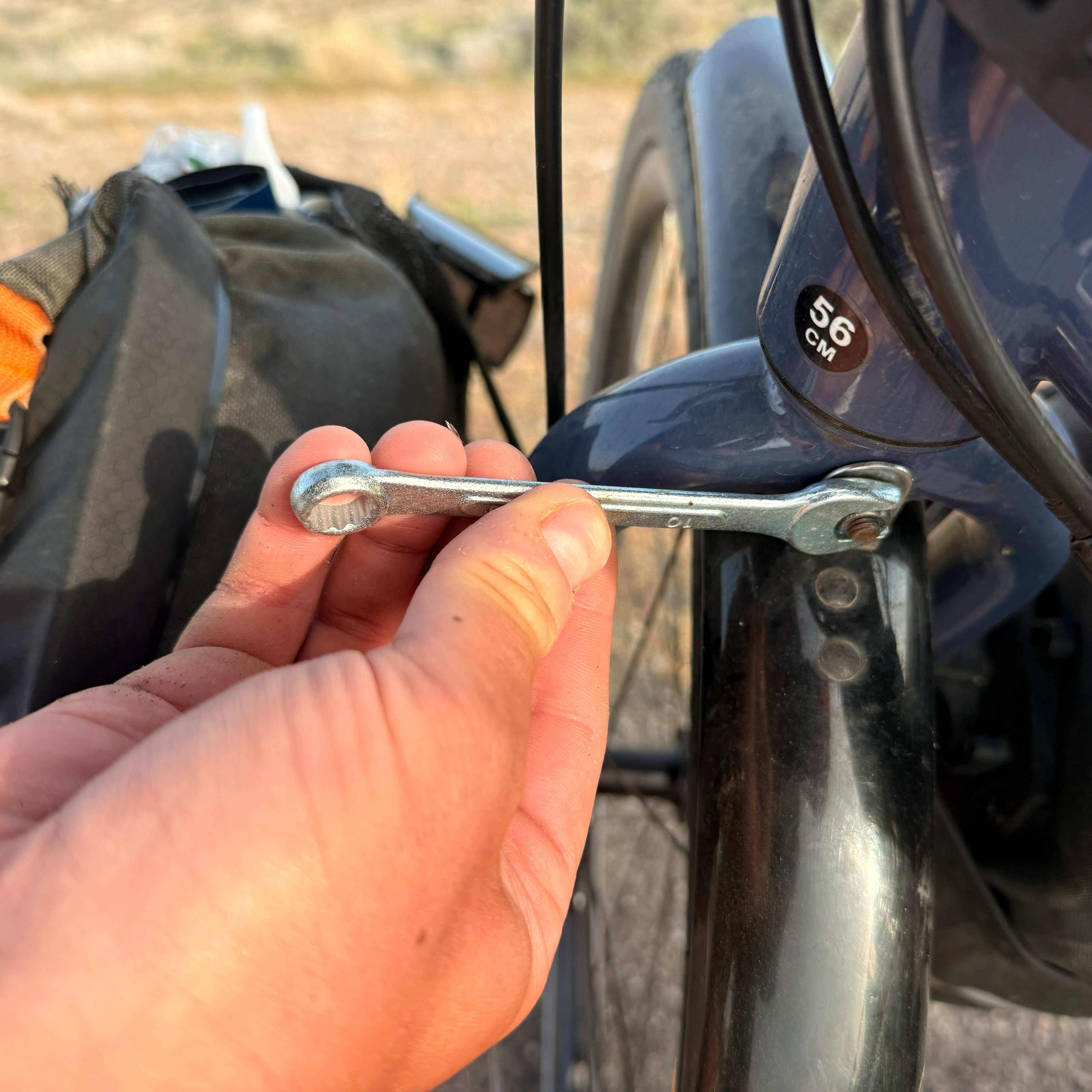 A found spanner tightening a bolt on the bicycle