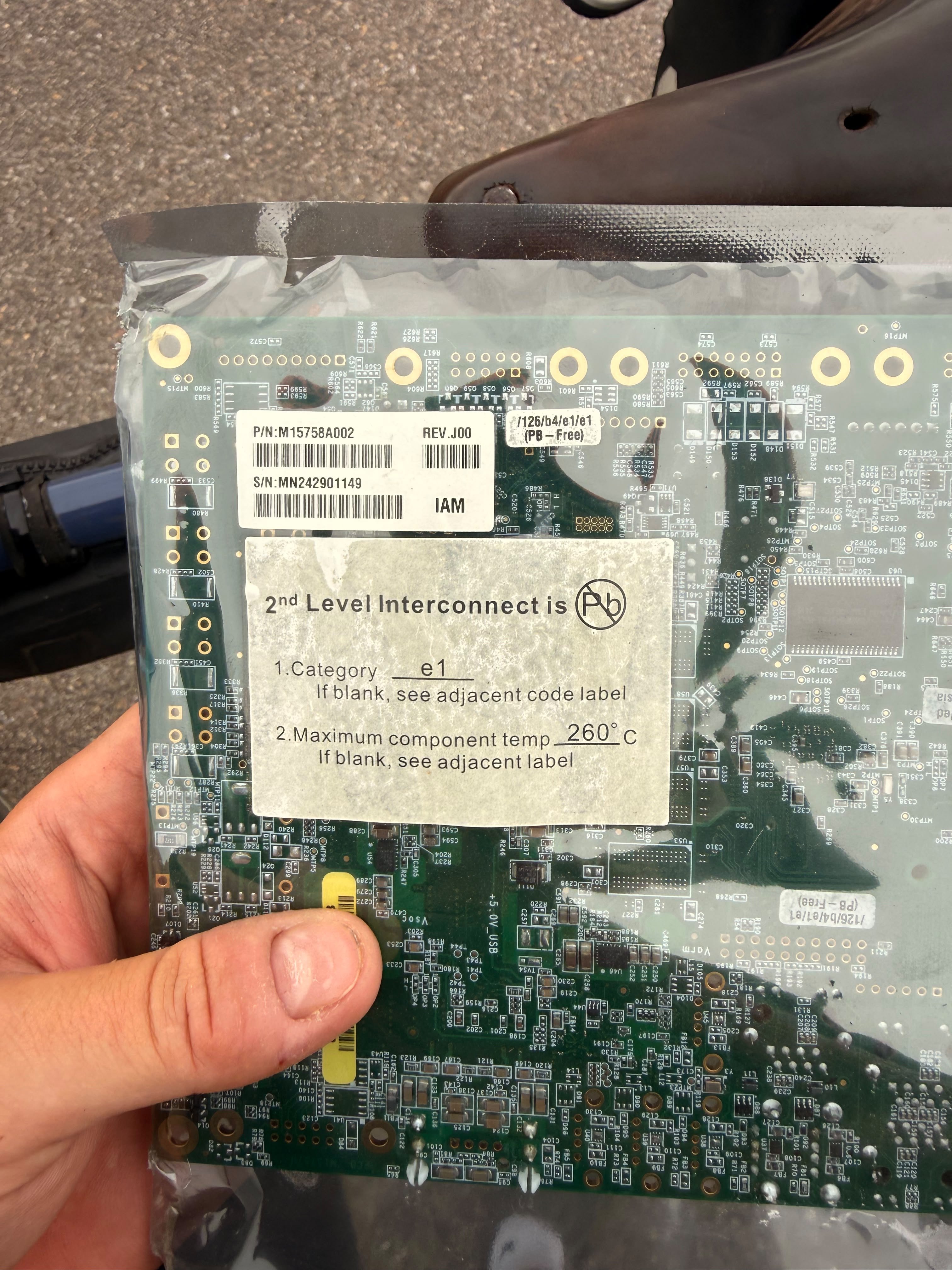 A circuit board in an anti-static bag, held in a hand