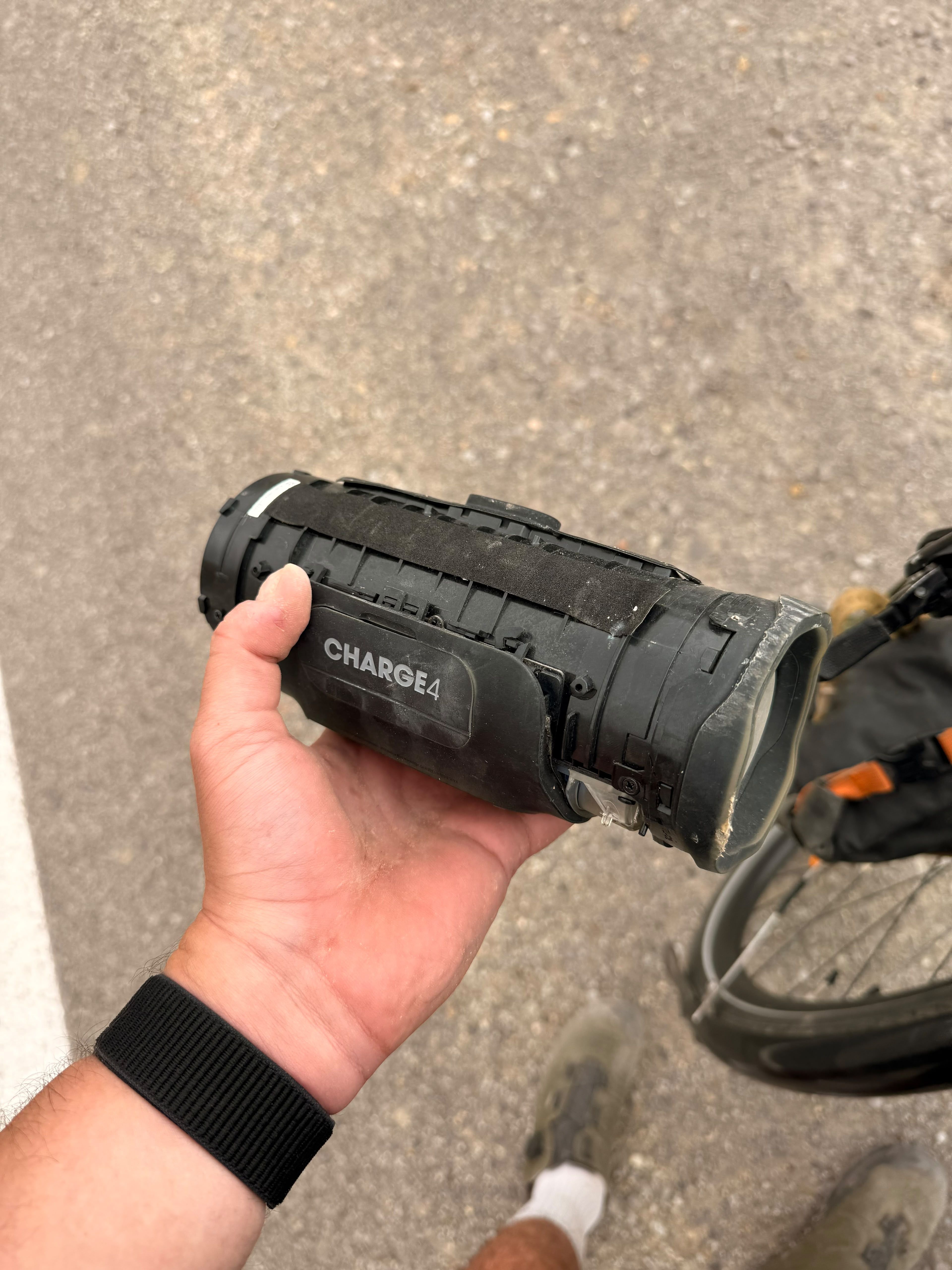 A cracked JBL Charge 4 speaker held in a hand