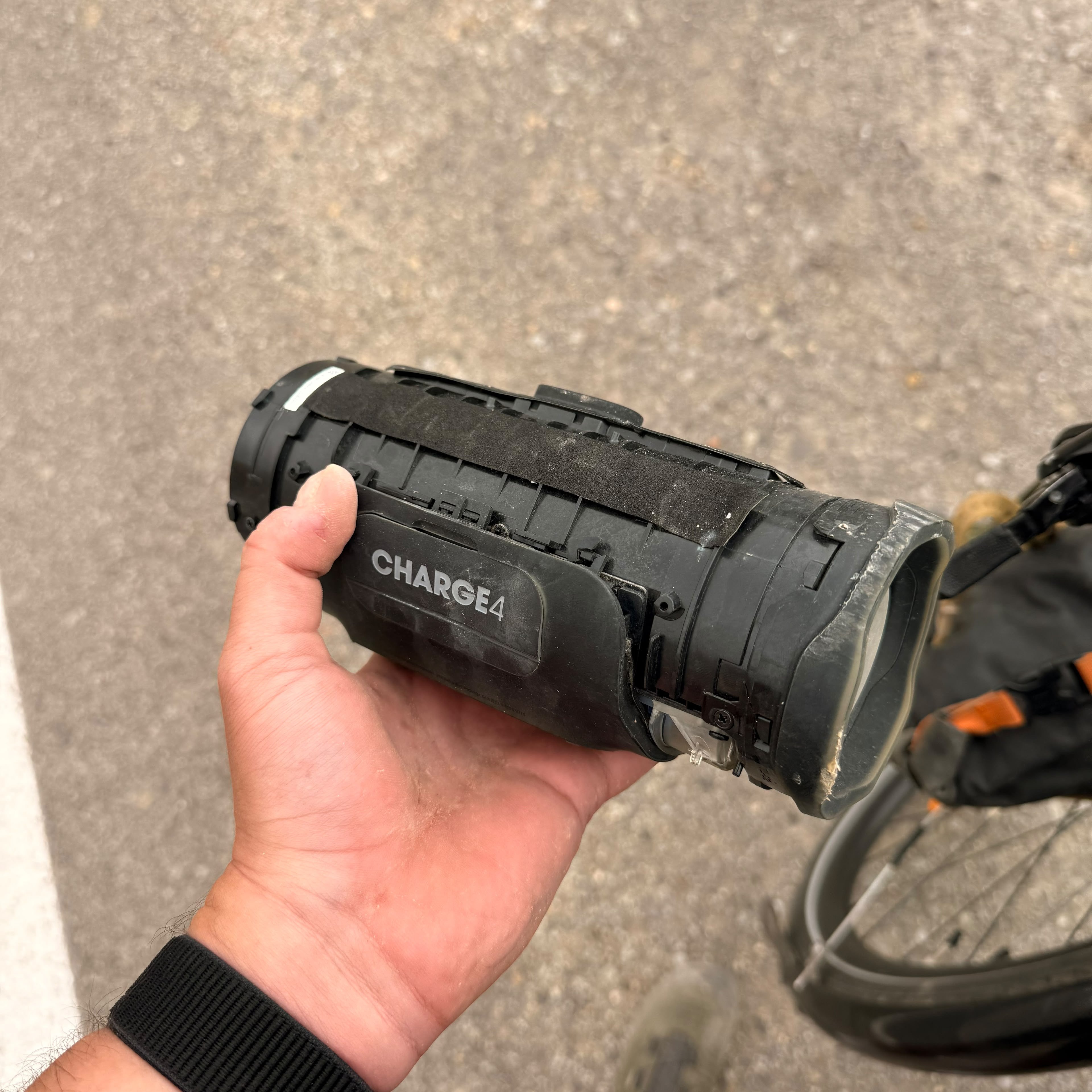 A cracked JBL Charge 4 speaker held in a hand