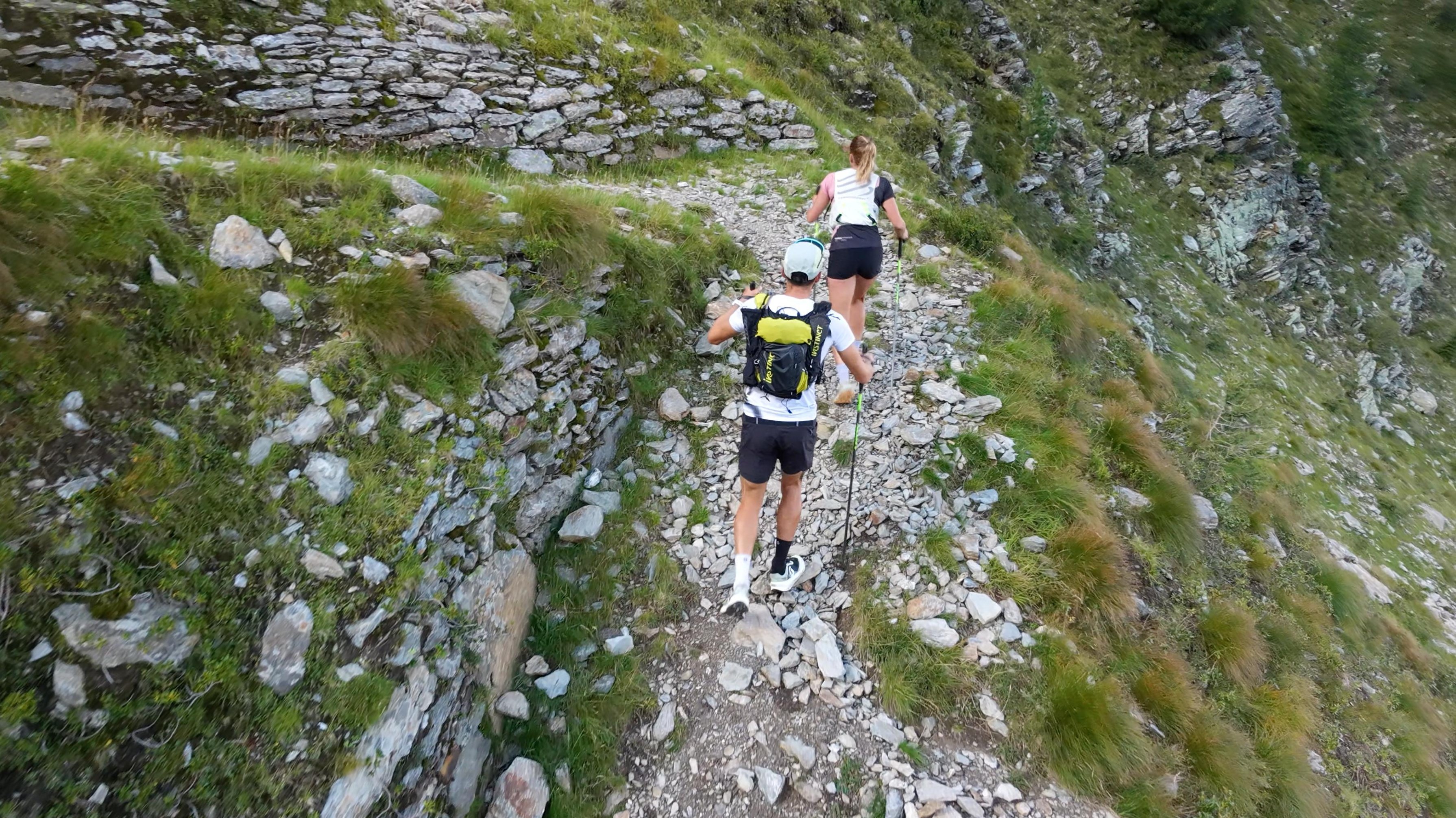 Frédéric and his girlfriend Morgane running on a rocky path next to a dry-stone wall.