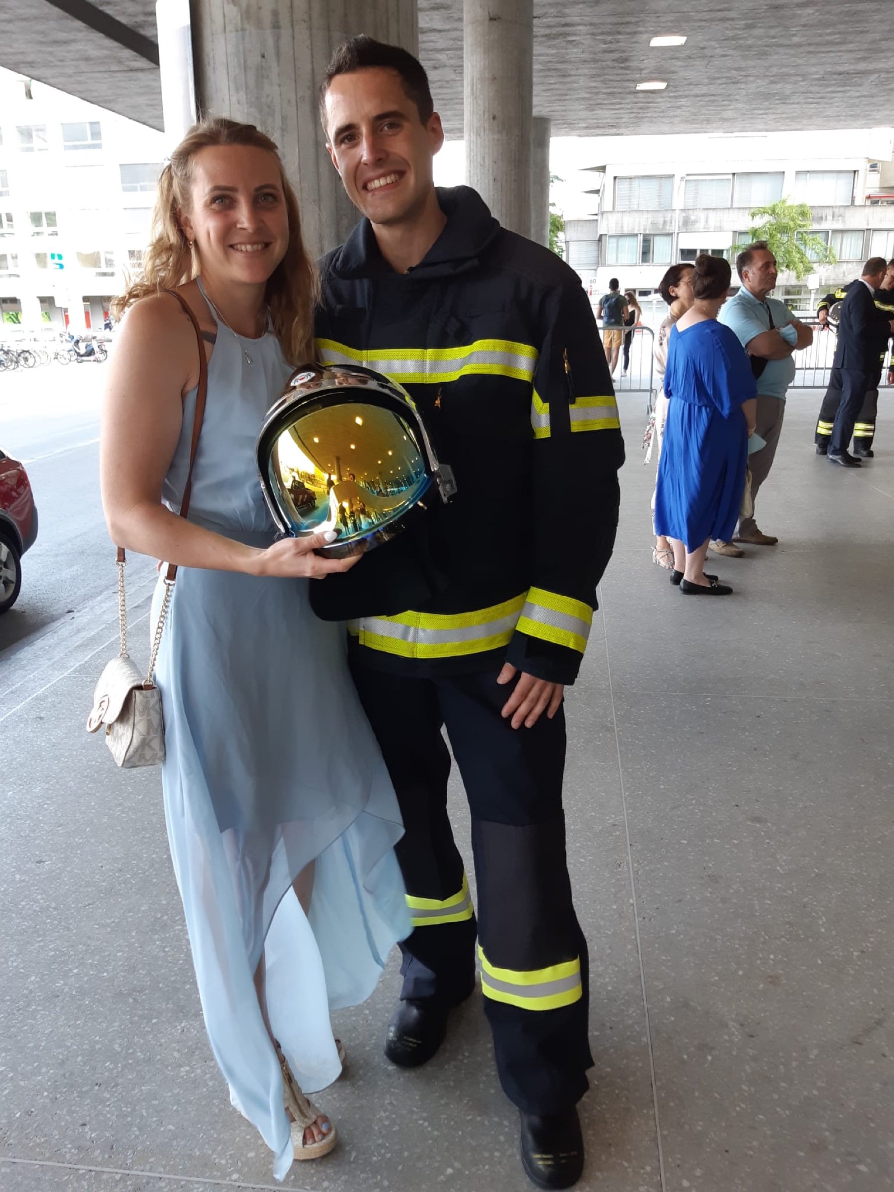 Frédéric in firefighter gear beside his girlfriend Morgane, who holds his helmet.