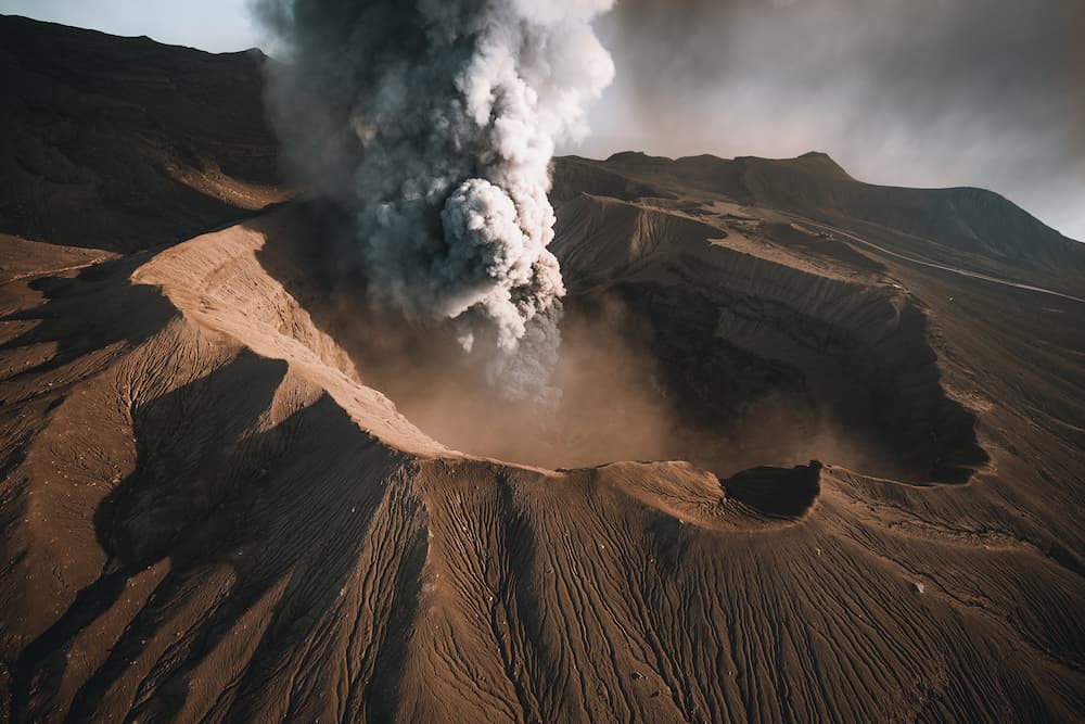 Aerial view of an erupting volcano crater