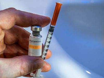 Physician preparing a ketamine injection in a clinical setting