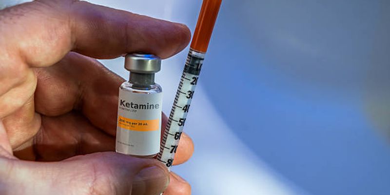 Physician preparing a ketamine injection in a clinical setting