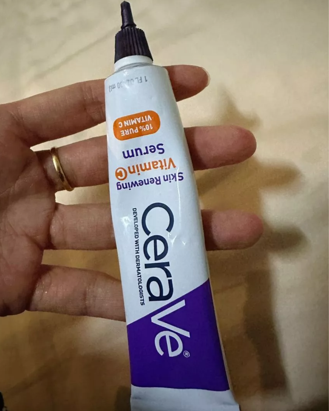 หลอดผลิตภัณฑ์ CERAVE Skin Renewing Vitamin C Serum บนมือของผู้ใช้