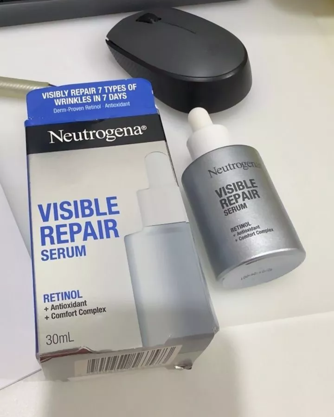 ผลิตภัณฑ์ Neutrogena Visible Repair Serum ข้างกล่องบรรจุภัณฑ์วางอยู่บนโต๊ะ