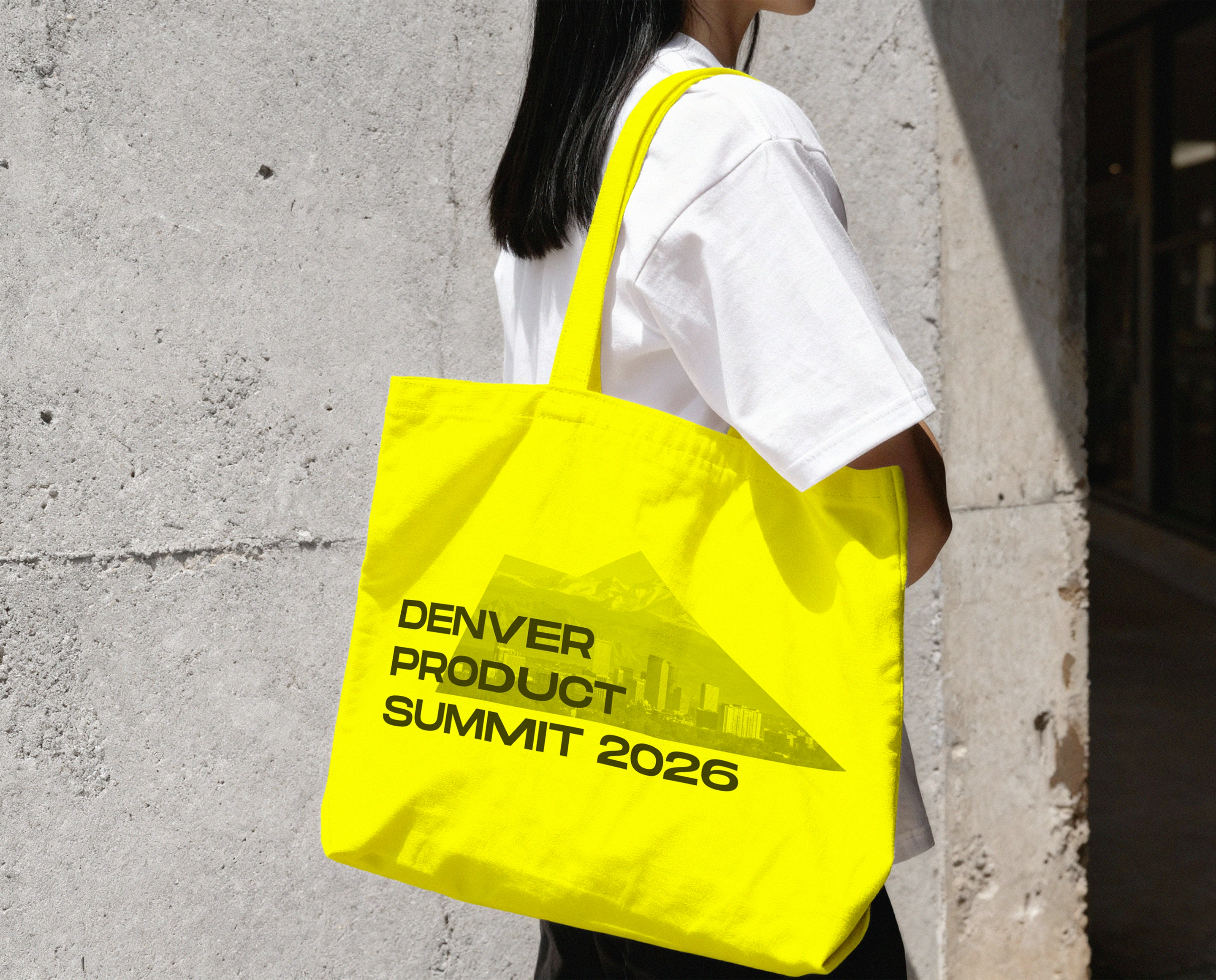 Bright yellow Denver Product Summit 2026 tote bag featuring the event's mountain-inspired logo and black typography.