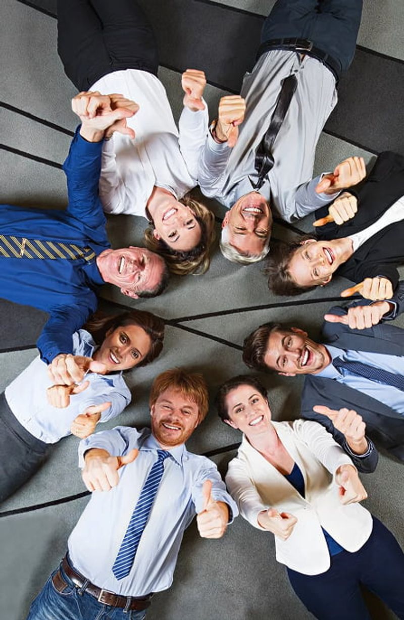 Diverse group of business professionals giving thumbs up