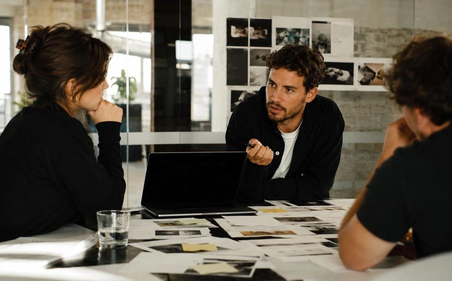 Strategieteam bespreekt klantinzichten rond een tafel vol onderzoek en campagnemateriaal