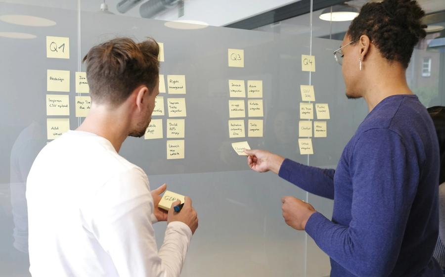 Team bepaalt de marketingstrategie met sticky notes op een glazen wand