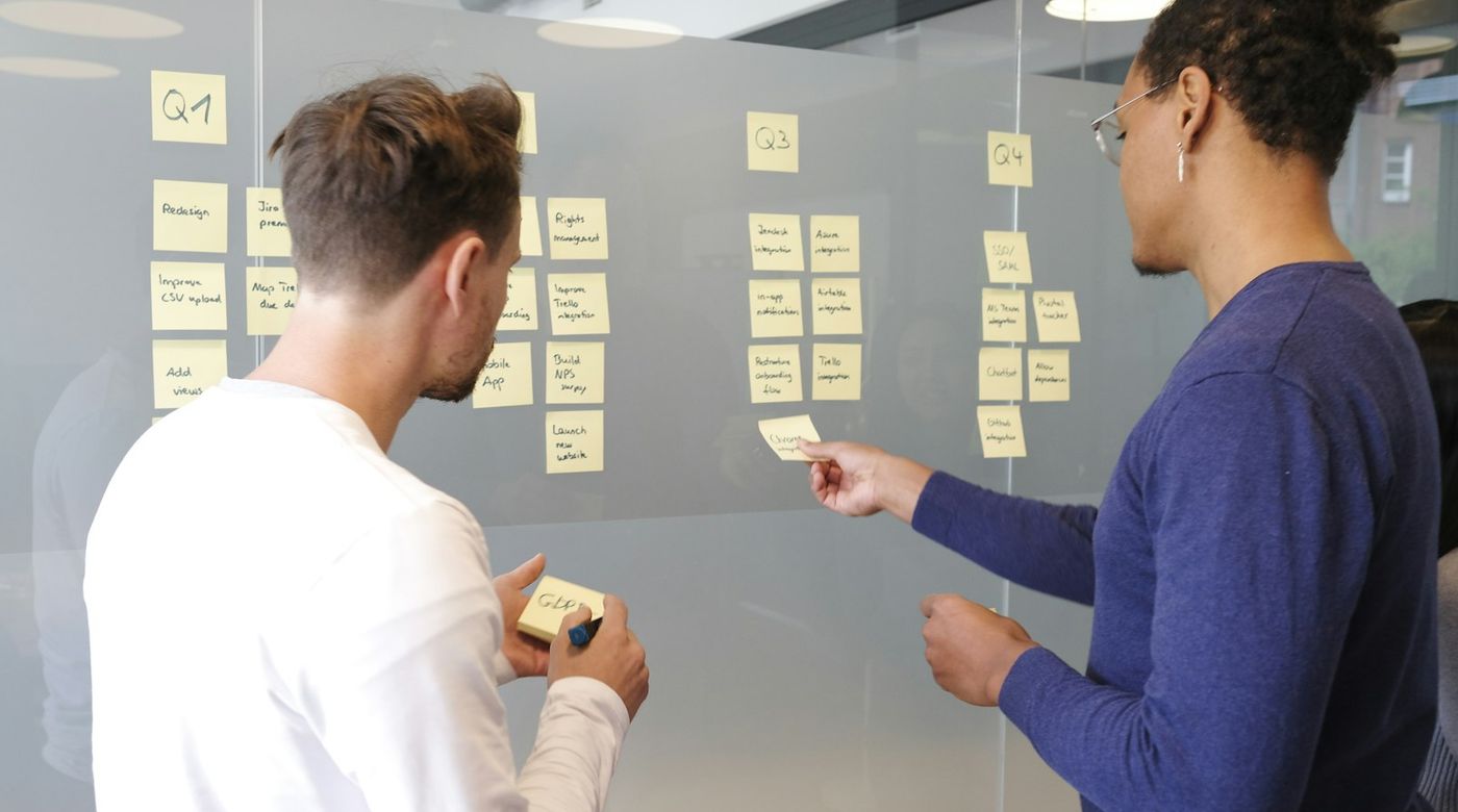 Team bepaalt de marketingstrategie met sticky notes op een glazen wand