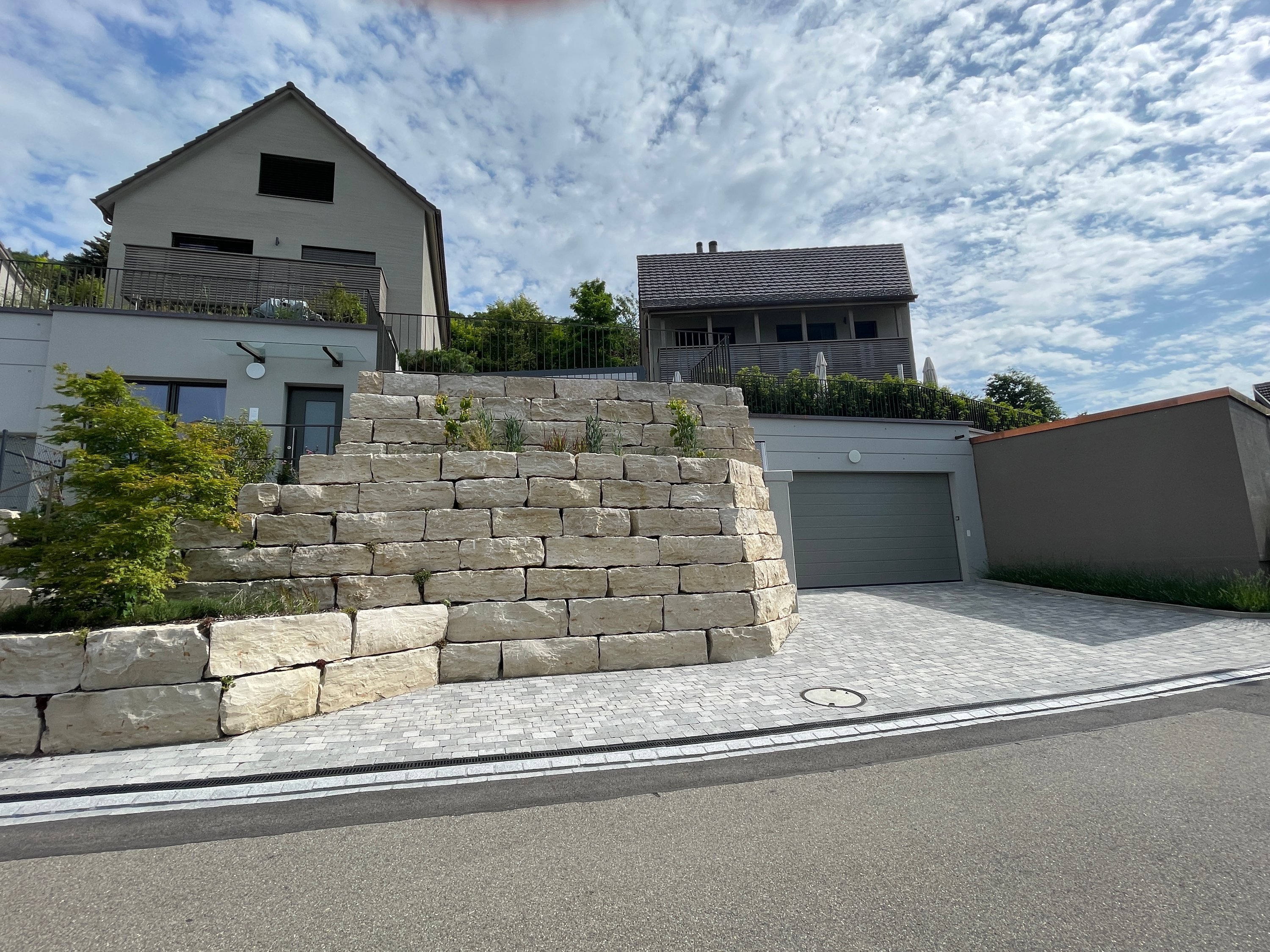 Terrassierte Natursteinmauern vor den Garagen