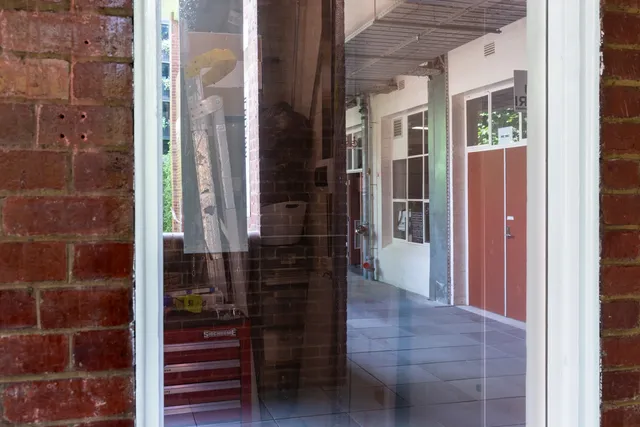 The storage facility of West Space faintly on view from outside a tall, narrow window.