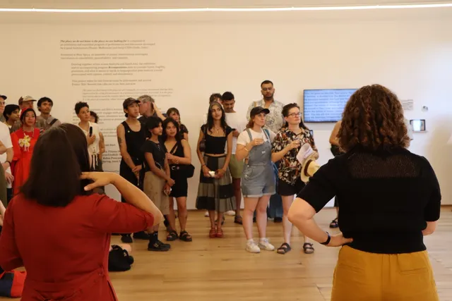 A group of people standing in the West Space exhibition space.