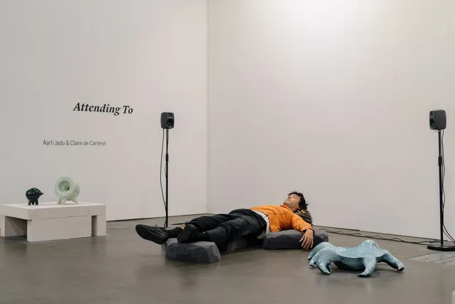 A person laying down and listening to Aarti Jadu and Claire de Carteret sound and installation work.