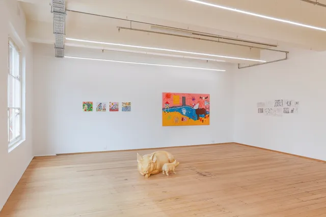 Wide-angle installation shot for the 'Slime and Ashes' group exhibition, with Abdul-Rahman Abdullah's wood pigs as a central focal point. On the two white walls behind the sculptures are Peter Waple-Crowe's four paintings, Jemi Gale's painting, and Keely Hallas's pen drawings. A large window lets in natural light from the left-hand side of the room, and the white ceiling lights can also be seen.