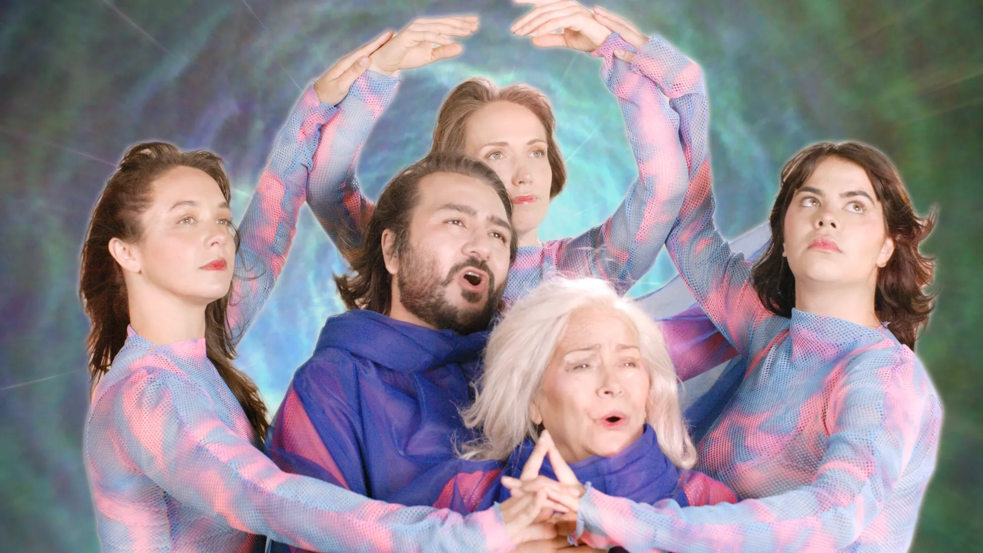 5 dream-like figures in blue and pink round their arms to create a giant halo hovering above one figure. The background is a psychedelic green glow. They all gaze upward.