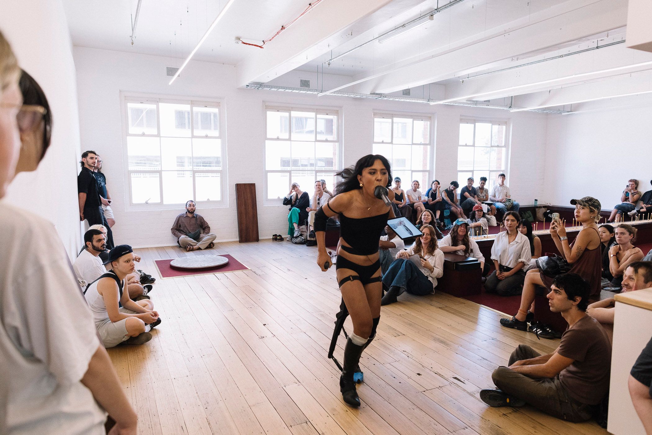 Ari running away from crowd with a microphone in her mouth.