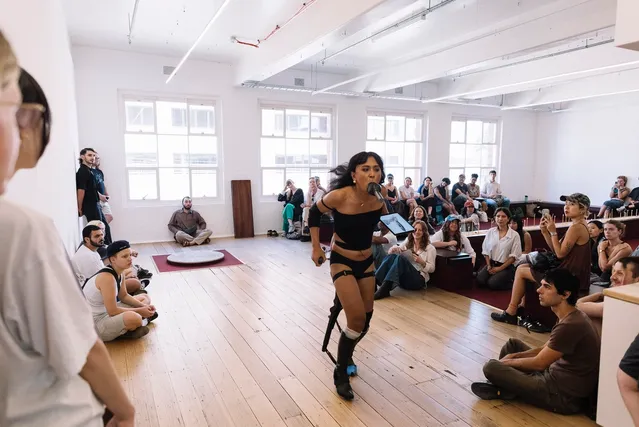 Ari running away from crowd with a microphone in her mouth.
