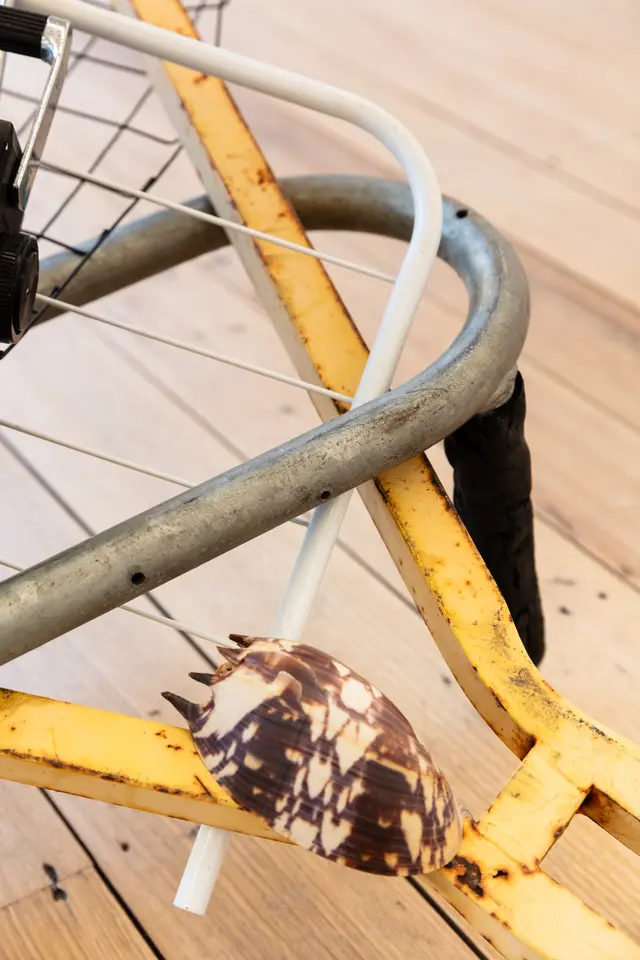 A detail image of three different metal frames intersecting, with a large baler shell sitting on top of the structure