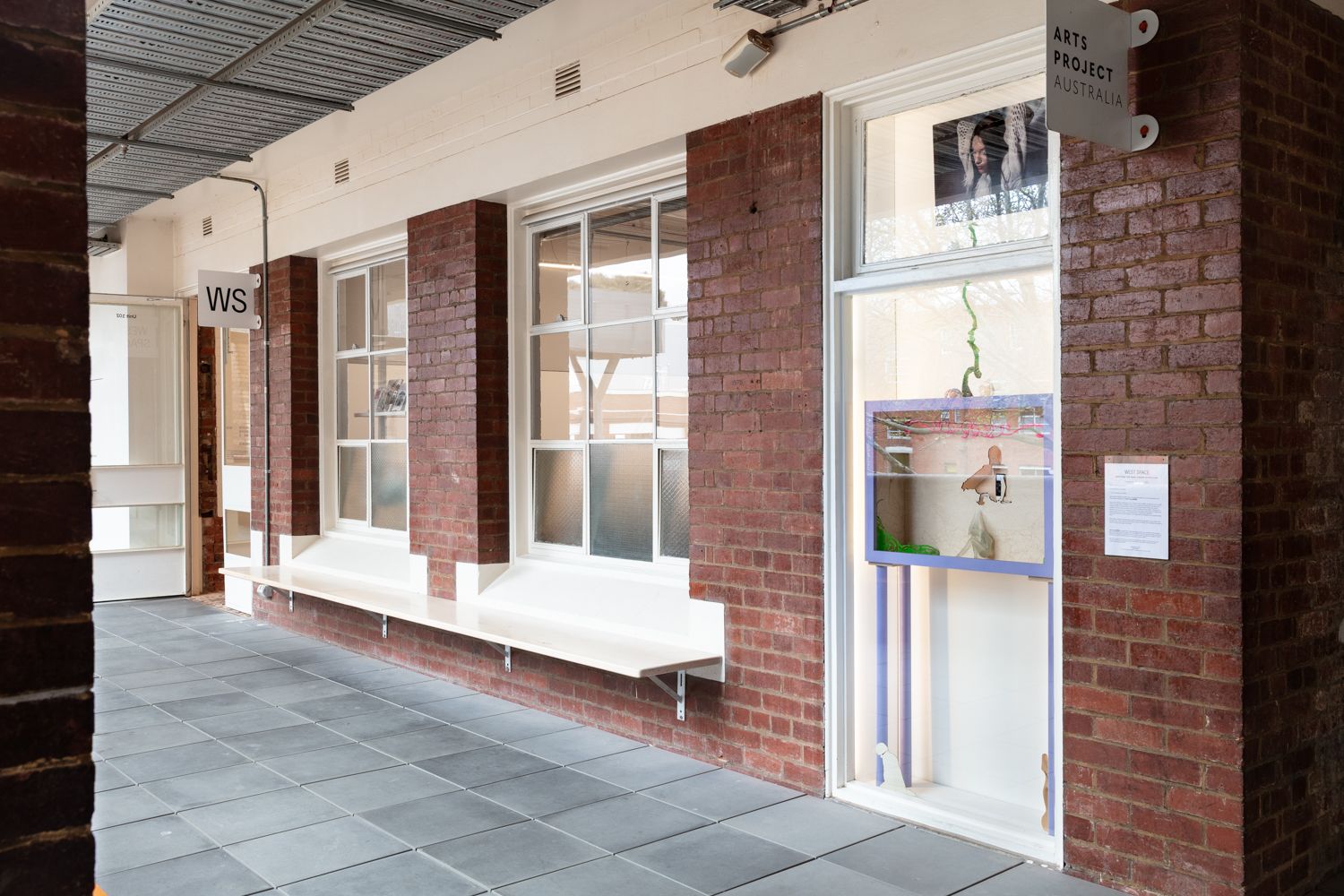 Exterior view of West Space with Yanti Pengs 'Self-made: Invisible Architectures' showing in the window.