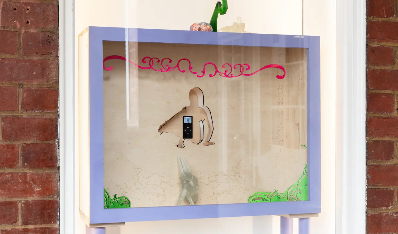 Installation view of the West Space window showing a wooden box containing a mixed media sculptural work.