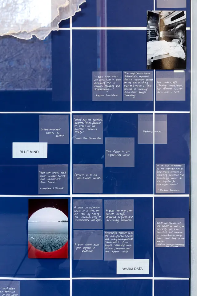 A background of deep blue squares with white intersections hosts a number of muted blue squares with white text. There are also two photographs, and a white sheer fabric in the top left corner.