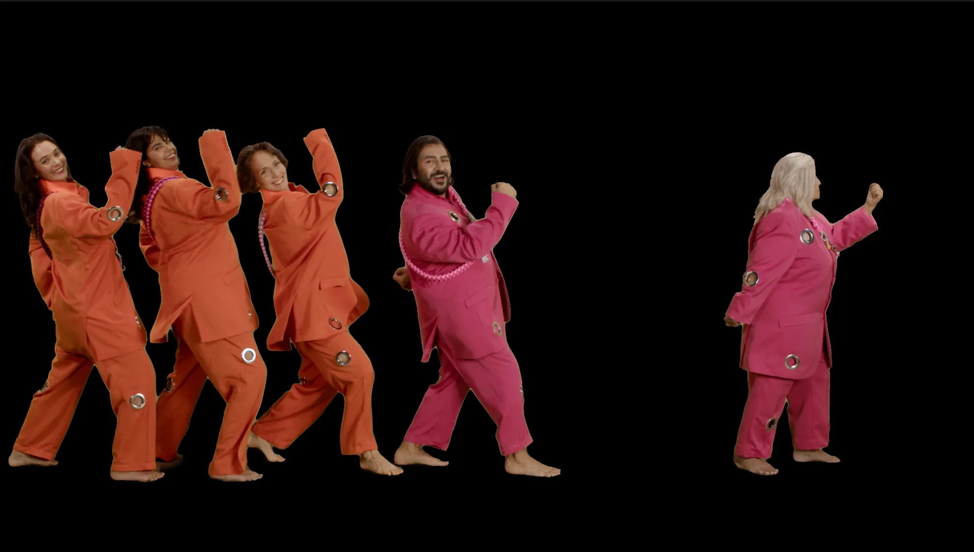 A photograph of five people in colourful suits with animated facial expressions, marching across a black background.