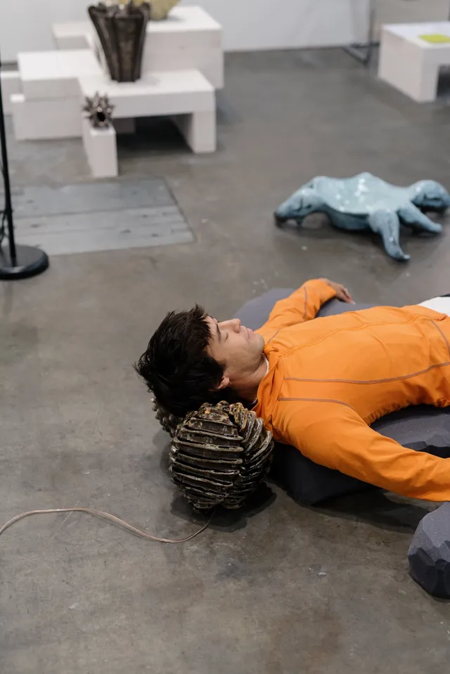 A person laying down and listening to Aarti Jadu and Claire de Carteret sound and installation work.