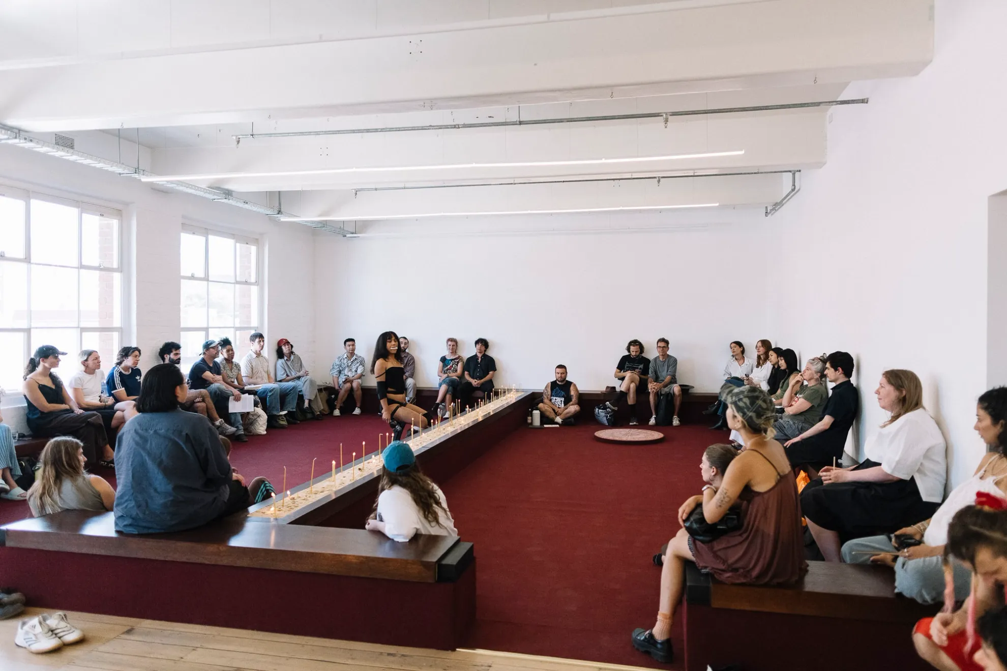 A group of people sitting on and around Tina's work.