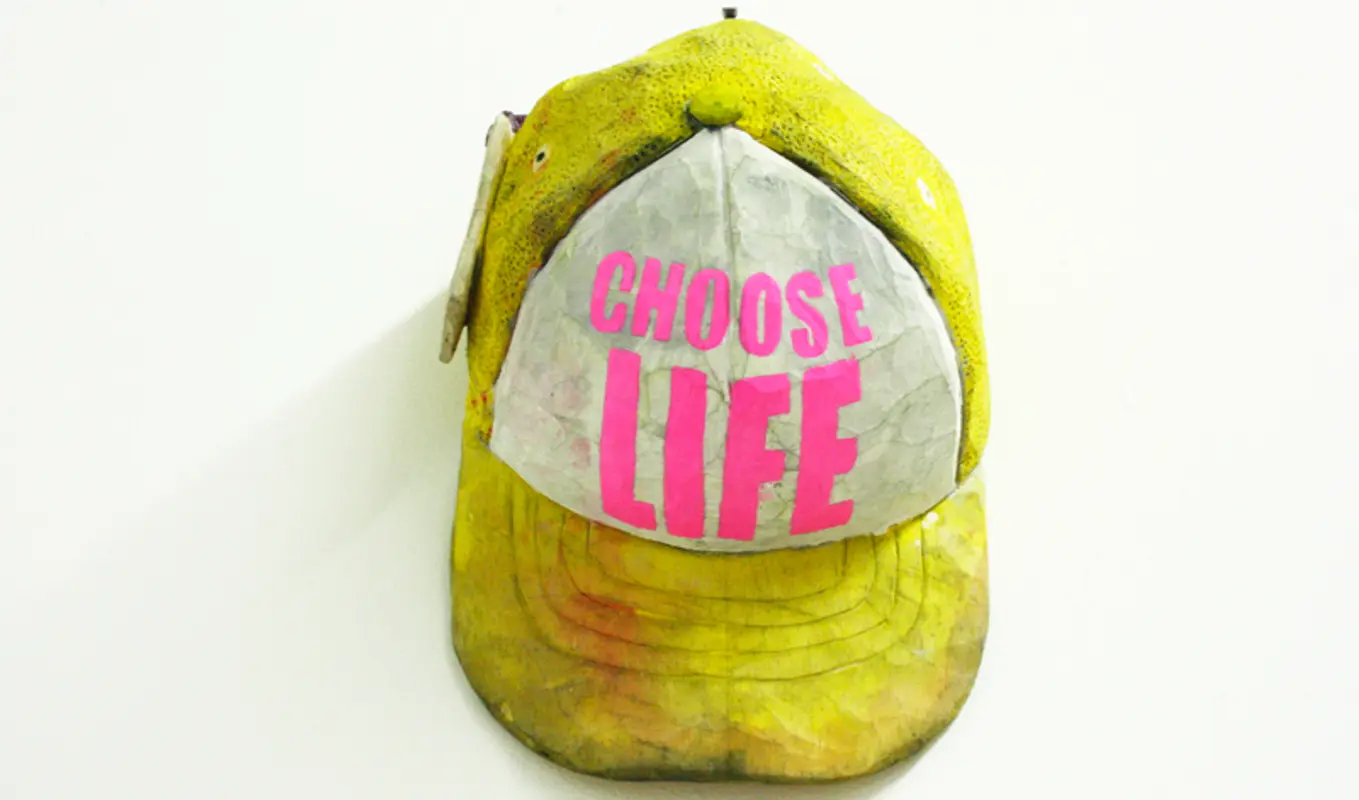 A worn out yellow and white cap with hot pink text that reads 'Choose Life'.
