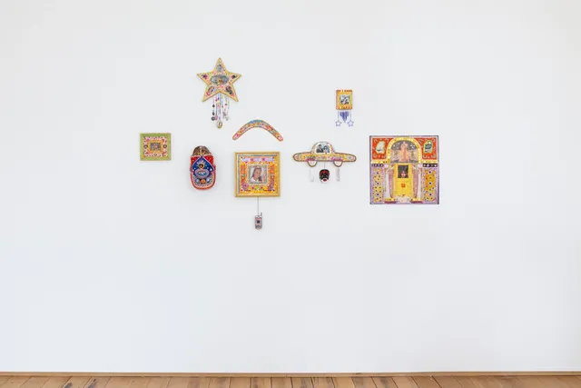 Aretha Brown's assemblages are seen hanging against a white wall, at about eye level. A small section of the floorboards can be seen at the bottom.