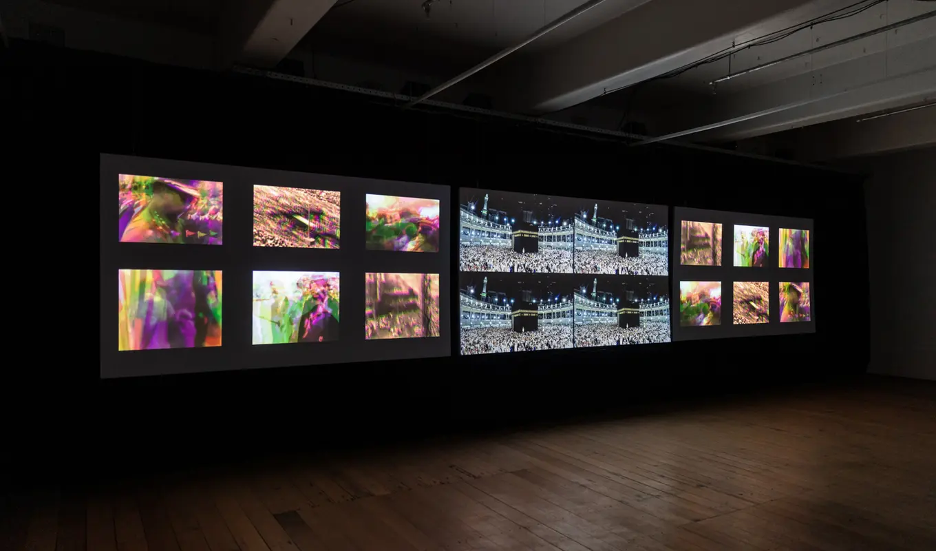 Three projectors display images in a dark room. From left to right, a series of six colourful photographs, four photographs, and the six colourful photographs again.