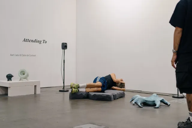 A person laying down and listening to Aarti Jadu and Claire de Carteret sound and installation work.
