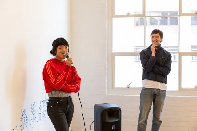 One person speaking to the microphone while the other person is looking.