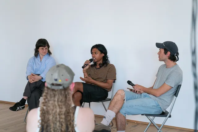 3 people sit facing an audience during a panel discussion at West Space.