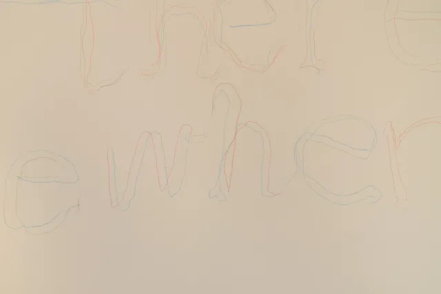 Orange, blue, green and pink pencil line drawings write the word 'somewhere' on a cream wall.