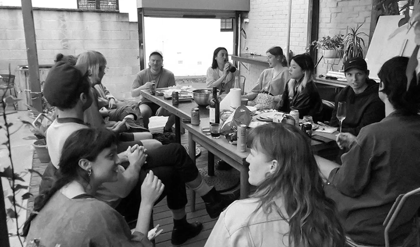 People at the table eating, drinking, and talking.