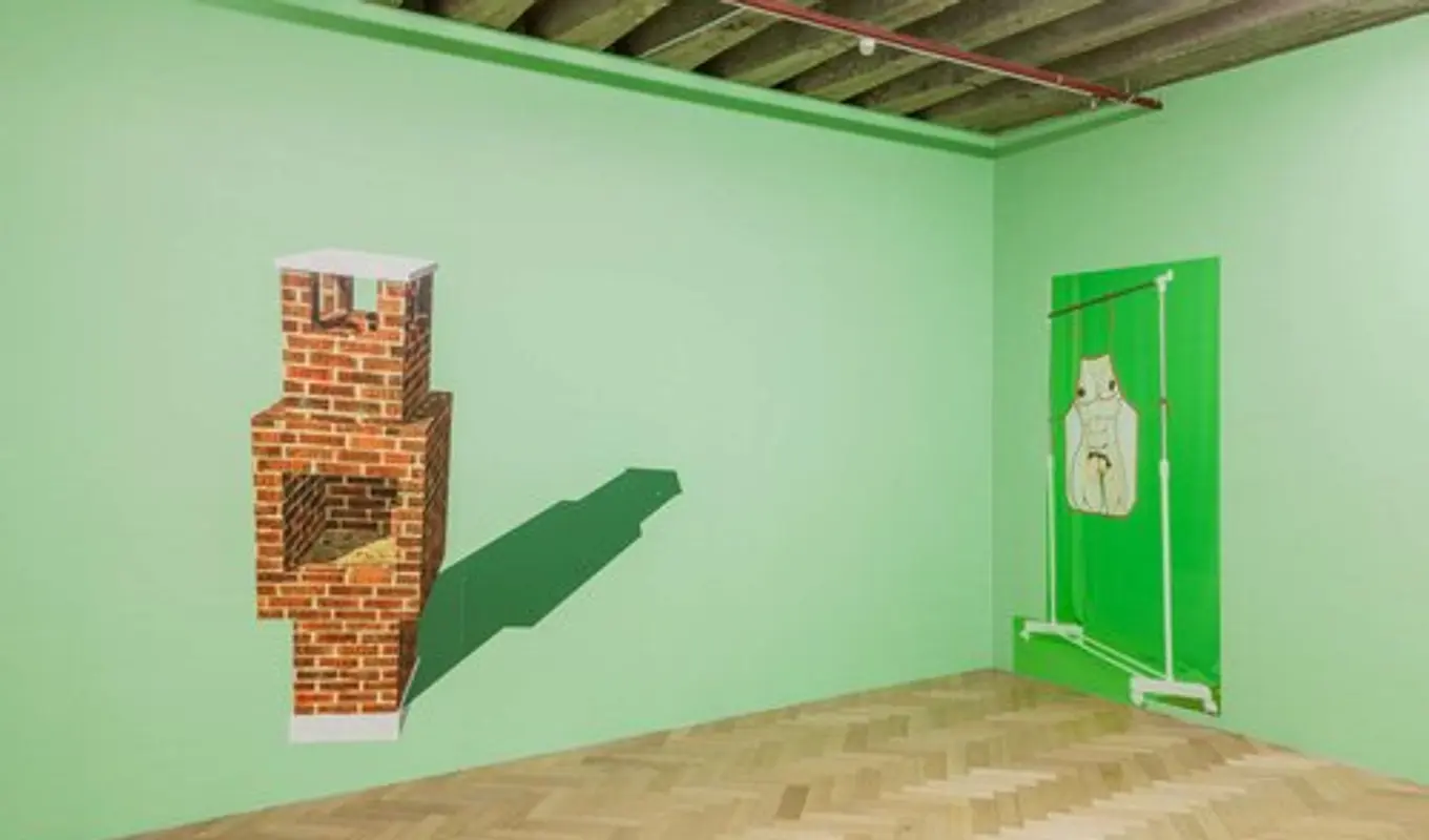 The walls are painted a tainted pastel green. The photograph is of the corner of a room. There are two works, both two-dimensional adhesives on the wall. One is of a free standing brick fire place with a deep green shadow, the other is of a flat green curtain with an adhesive sticker of a clothes rack. Hanging from the clothes rack is an apron with a nude model on its, in a linear drawn technique.
