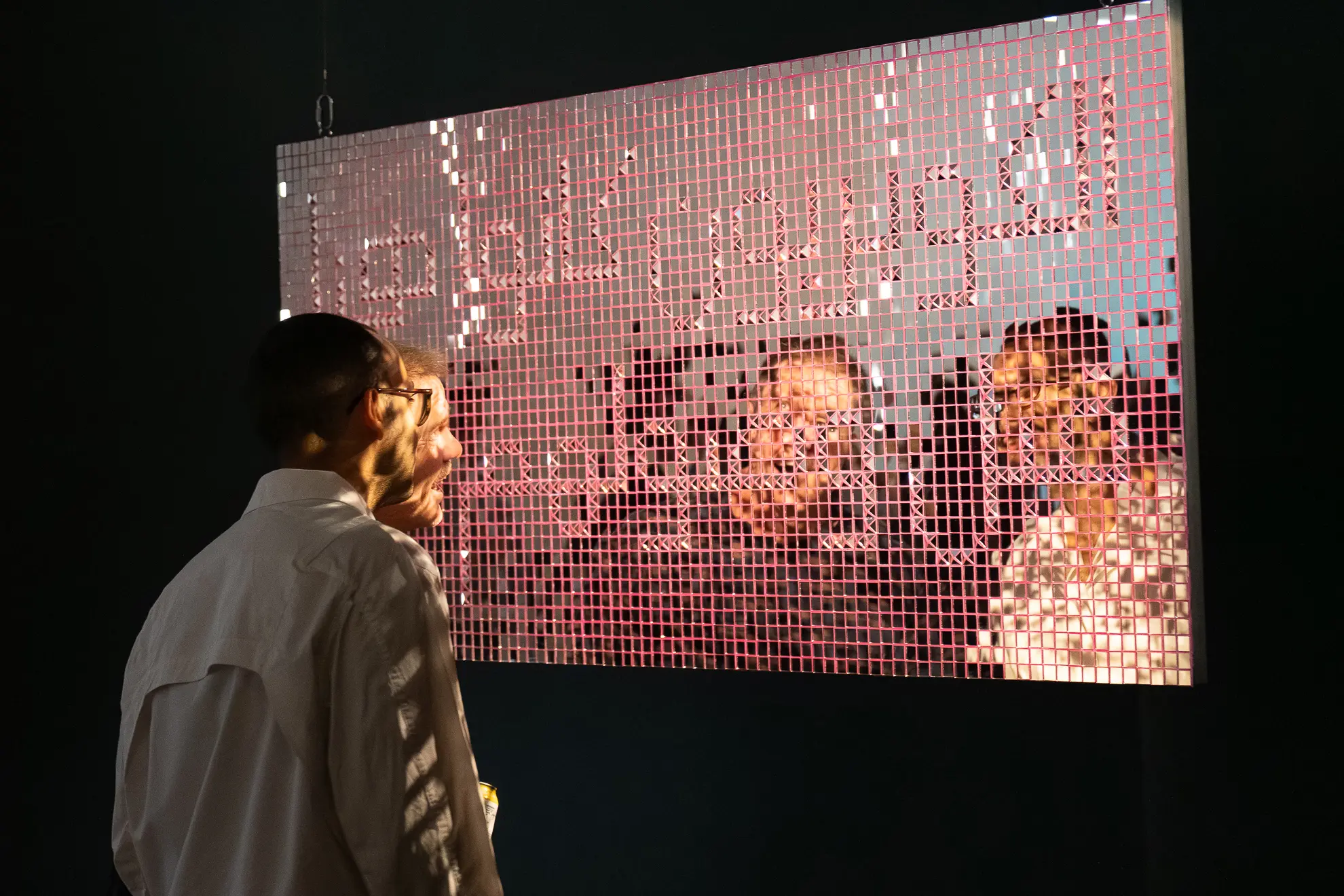 Two people stand in front of a mirrored mosaic artwork showing their abstracted reflections and dappled light :)