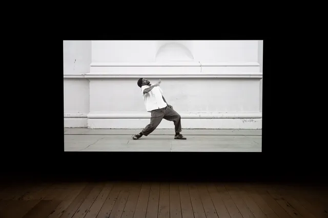 A large black and white projection showing a dancer in motion.