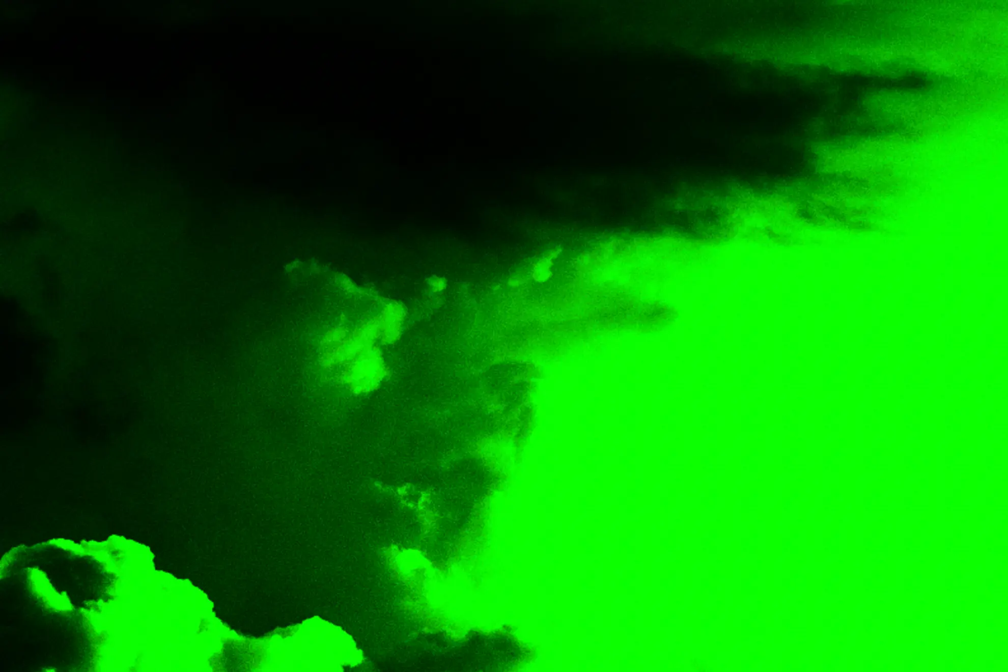 A dark, cloud-like shape appears against a bright green background, creating a stark contrast.