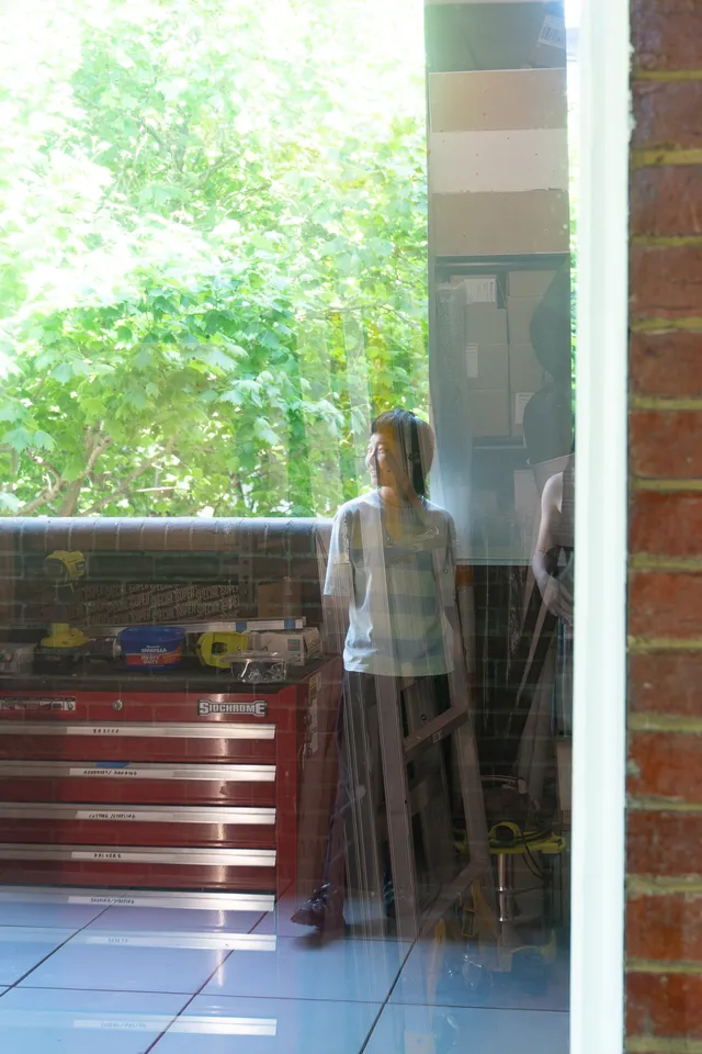 The glass reflection of a person standing.