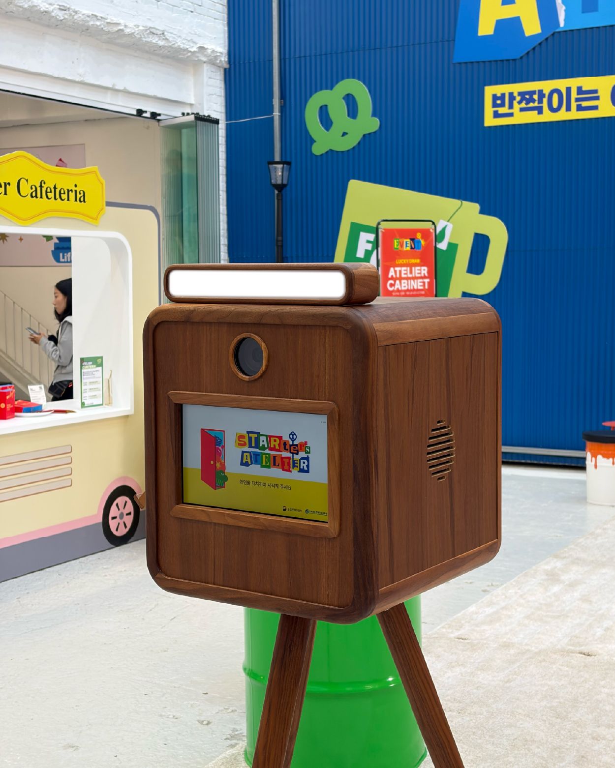 브랜드 전용 프레임이 화면에 띄워진 원목 박스형 모던피키 포토부스 정면