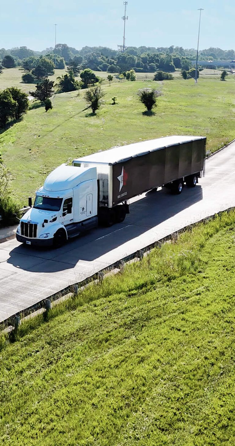 A large semi truck driving on an empty road