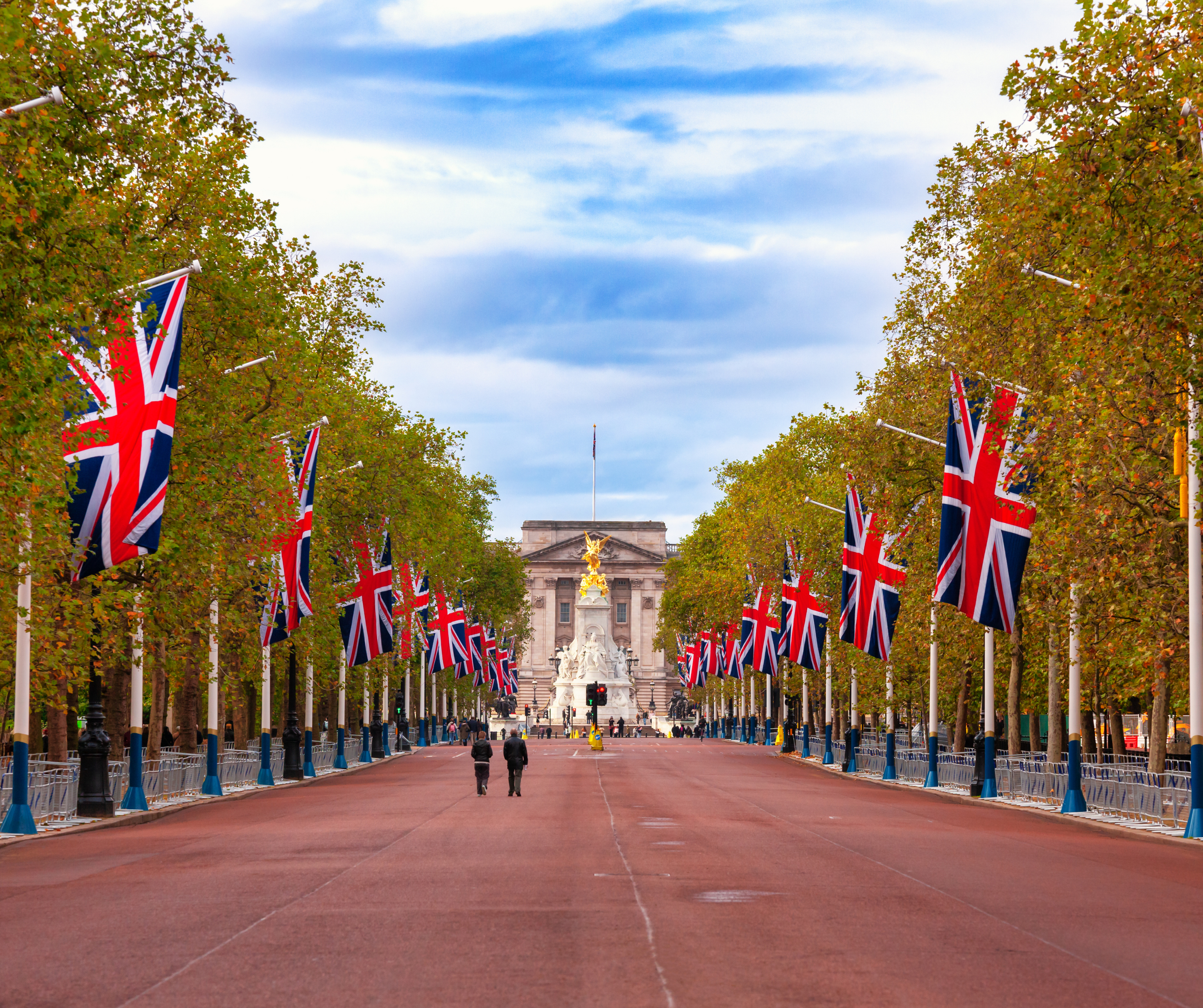 The Mall in London lined with Union Jack flags, with Buckingham Palace in the background.